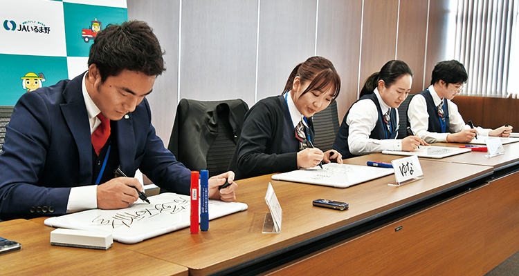 それぞれのフリップに書き入れる湯浅職員、石田職員、須田職員、山口職員