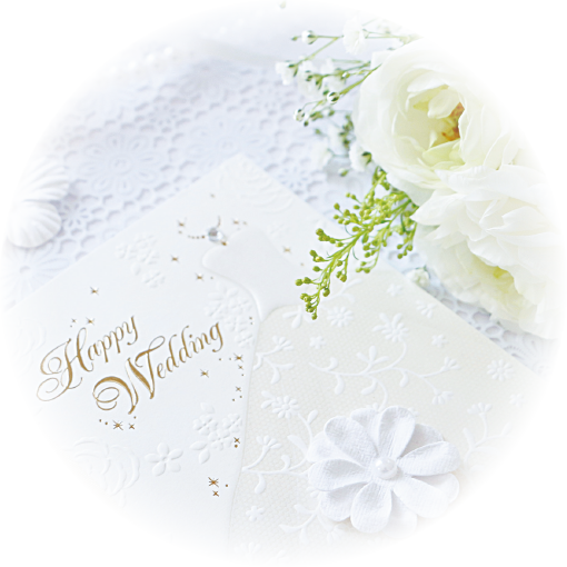 白いバラのブーケと結婚式の招待状の写真